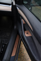 Tesla Model 3 Second Generation with walnut real wood covering the door buttons and door step