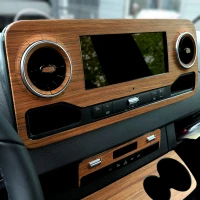 Detail of the Sprinter Van dashboard and center console wrapped in real wood.  Toast interior kit in teak.
