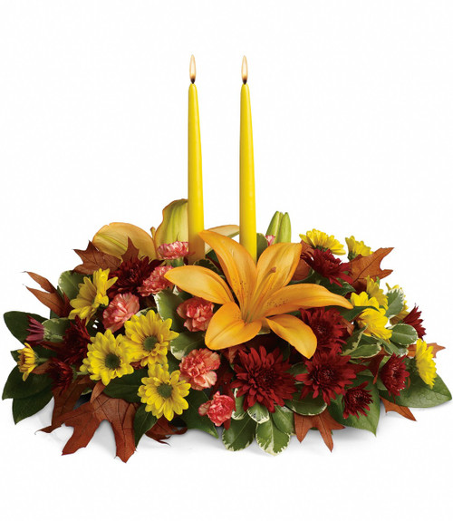 The magnificent arrangement includes orange asiatic lilies, orange miniature carnations, yellow daisy spray chrysanthemums, burgundy cushion spray chrysanthemums accented with oak leaves and assorted greenery. Includes two 12" yellow taper candles.