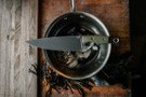 Benchmade Chef knife laying over a kitchen pot.