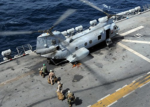 US Marines board a CH-46 Sea Knight helicopter on the flight deck of USS Peleliu Poster Print by Stocktrek Images -17 x 11-