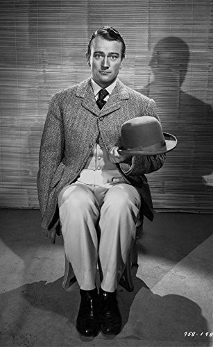 John Wayne sitting on a Chair and Holding His Hat Photo Print (8 x 10)
