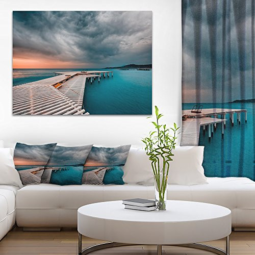 Designart PT9333 20 12 Pier in Ocean in Cloudy Day Seashore Photo Canvas Print, 20" x 12", Blue Designart PT9333 20 12 Pier in Ocean in Cloudy Day Seashore Photo Canvas Print, 20" x 12", Blue