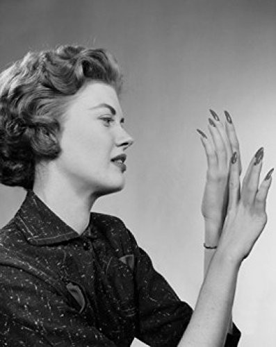 Posterazzi Side profile of a young woman looking at her fingernails Poster Print (18 x 24)