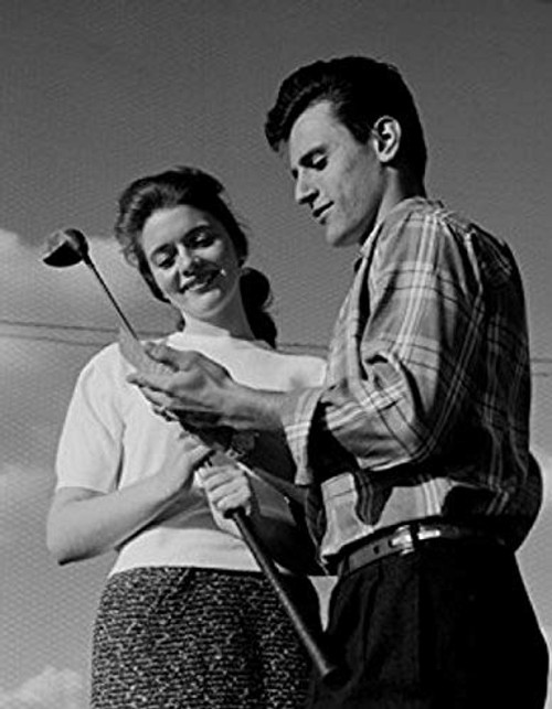 Young couple holding golf club and smiling low angle view Poster Print  18 x 24