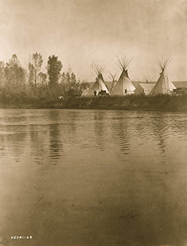 Crow encampment with tipis tents wagons horses and men as seen from the distant shore of the river Poster Print  18 x 24