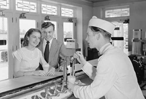 Young couple talking with barman at bar counter Poster Print (18 x 24)