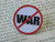 Peace lapel pin WAR with red slash