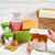 hands opening. box of rolls surrounded by other colorful boxes, rolls, and cookies