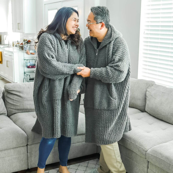 laughing couple wearing gray snuggle suit