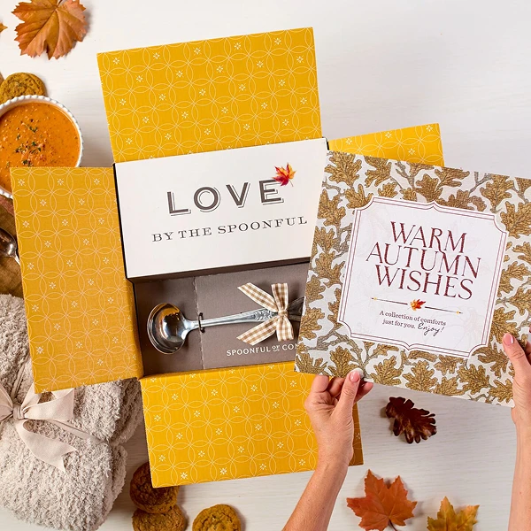 Overhead image displaying "Warm Autumn Wishes" card, Spoonful of Comfort Box, styled with soups, rolls and cookies.