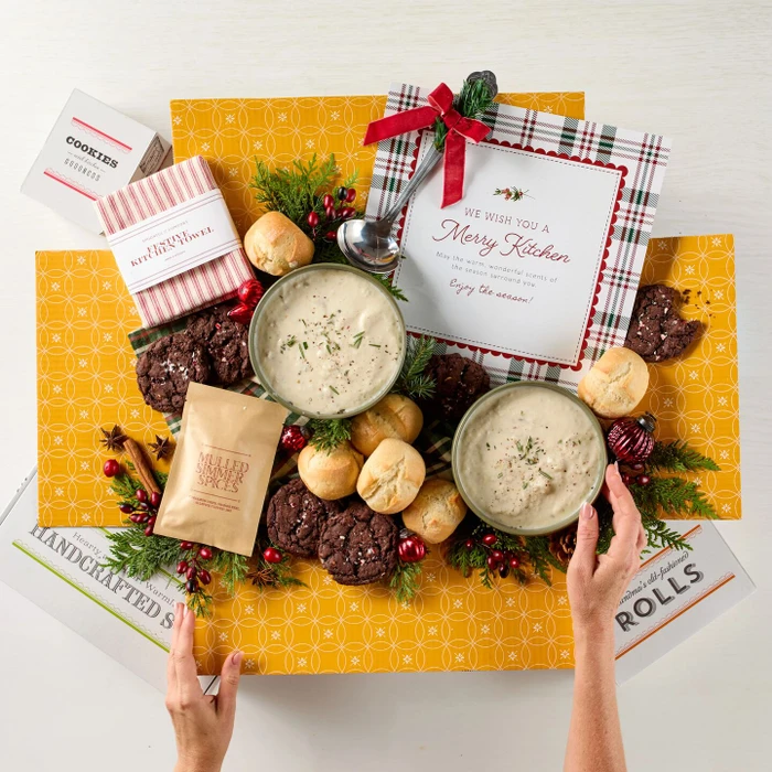 Soup package with a decorative insert, with two bowls of soup, rolls and cookies.