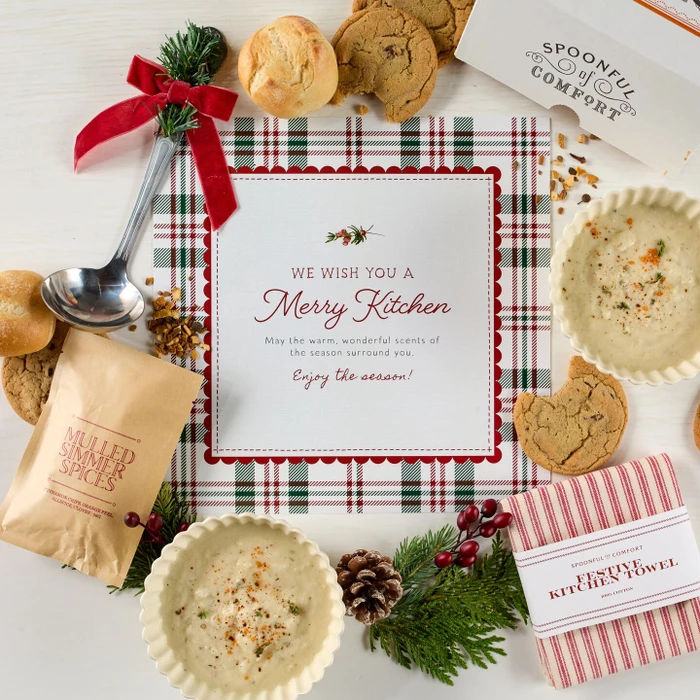 Soup package with a decorative insert, with two bowls of soup, rolls and cookies.