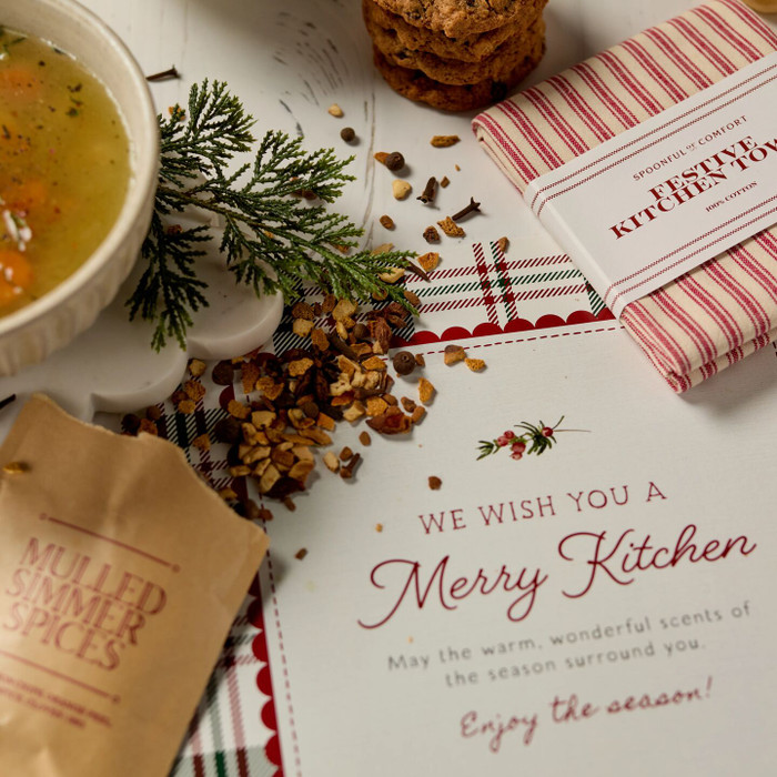 Soup package with a decorative insert, with two bowls of soup, rolls and cookies.