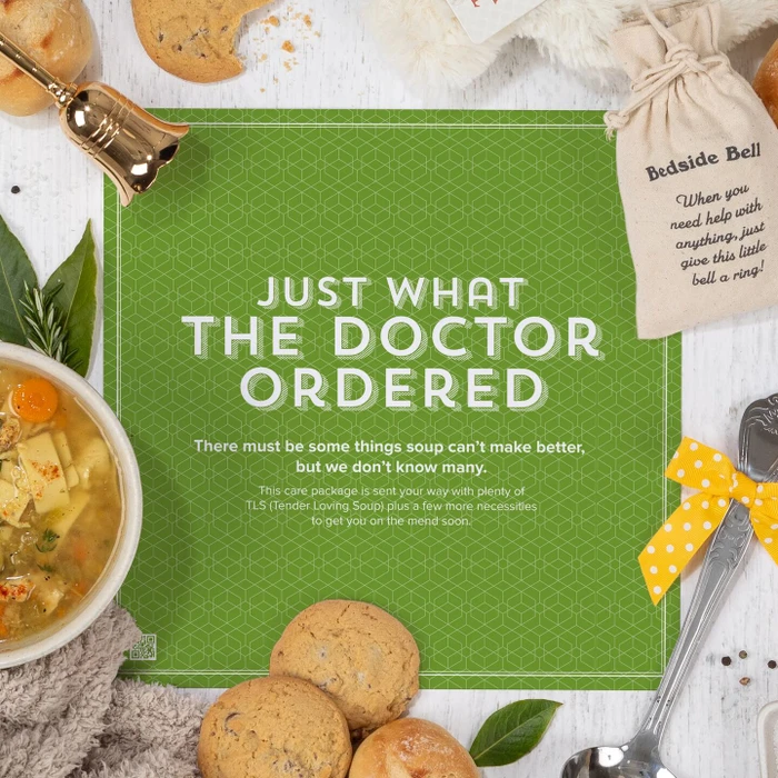 Get-well-themed arrangement with a bowl of soup, rolls, cookies, greenery, and a metal ladle with a yellow ribbon, featuring a green card that reads “Just What the Doctor Ordered.”