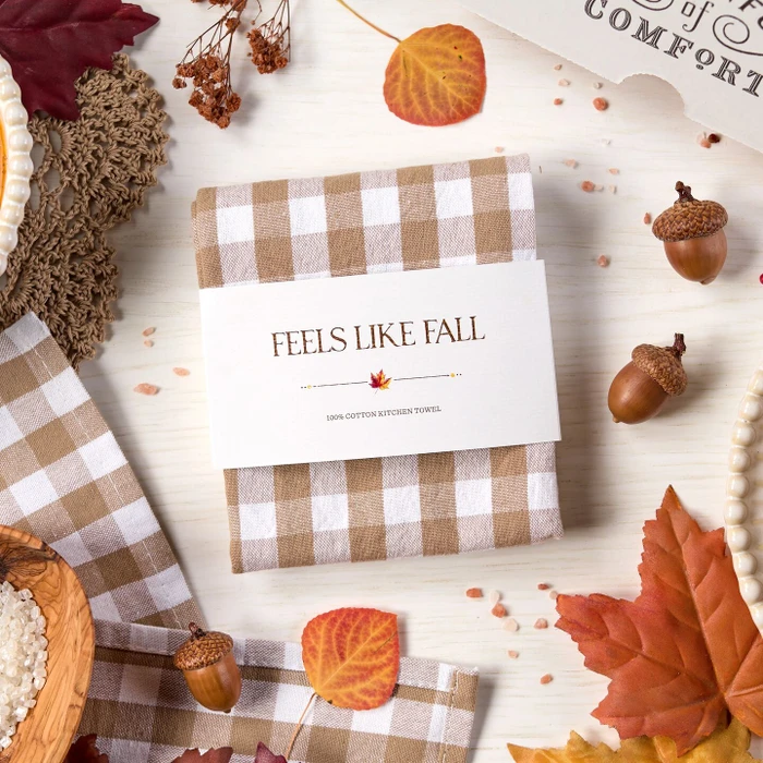 "Feels Like Fall" gingham themed towel surrounded by acorns, leaves and fall embellishments