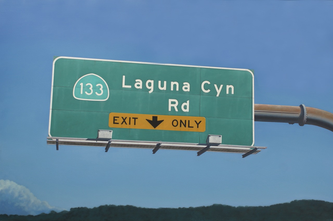 Photorealistic oil painting of a Laguna Canyon Road exit sign floating against a bright blue sky above distant dark green hills. Laguna Canyon by Eric Nash, Oil on canvas, 48” x 72” 2026, $16,500