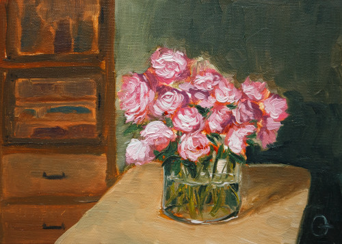 Small oil painting of a large bouquet of pink peonies. There are 15 flowers visible, they stand in a large cylindric glass vase on a yellow wooden table. The room in the foreground is dark green. There is a brown wooden cabinet to the left that has two cabbies with glass doors at the top and two drawers at the bottom. The painting is five by seven, oil on linen panel.