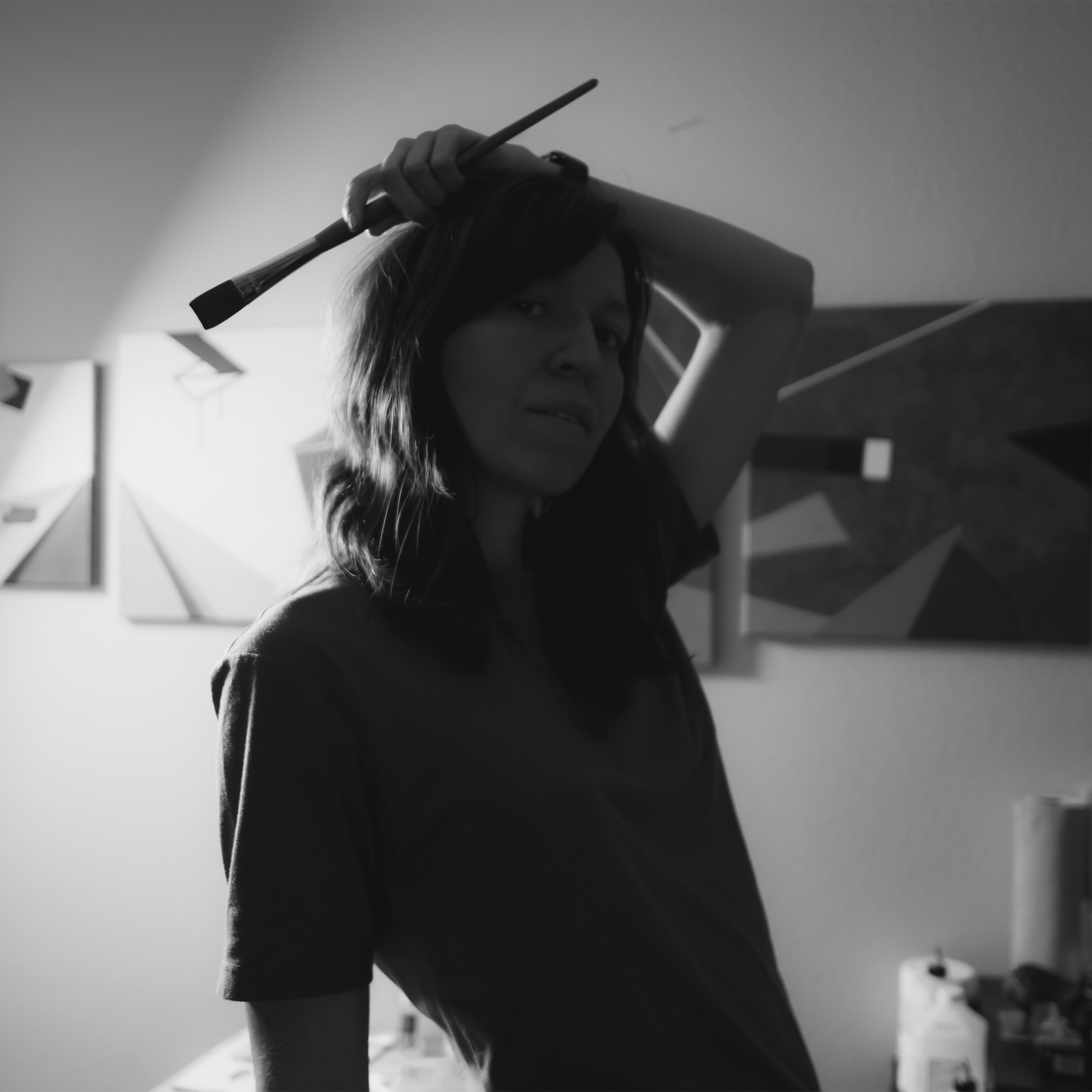 Black and white portrait of artist Oksana Ossipov in her studio