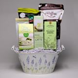 This cream container with lavender motif is loaded with exquisite gourmet treats! Key Lime Shortbread, Vanilla Matcha Latte Drink Mix, and Salted Caramel Biscuits, just to name a few. Salty, sesame Pressels and Utoffea Chocolate Drizzled Popcorn (Made in Manitoba) are also included in this basket that is sure to please! Order online today! 