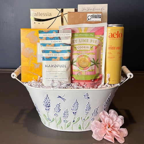 Filled with delicious treats such as chocolate biscotti, key lime cookies, cashews, Aelo cocktail mix, and exquisite lemon crackers from Fine Cheese Co, this beautiful lavender container with handles is sure to please all who are lucky enough to receive it! Order yours today! 