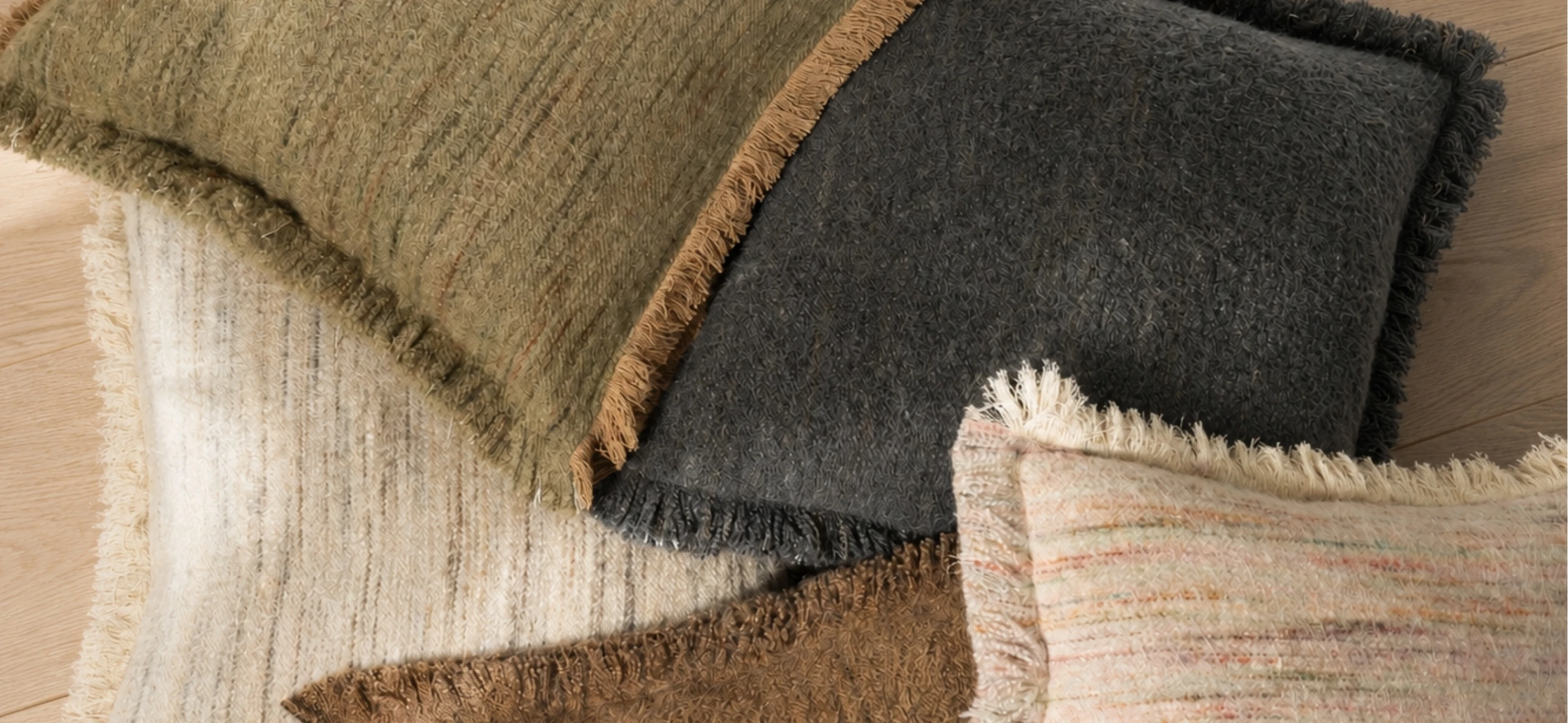 Fringed wool and linen pillows in olive, charcoal, and cream