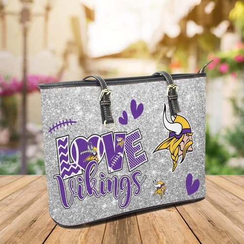  NFL.MINNESOTA VIKINGS TEAM/LOVE-THE-VIKINGS-TEAM-DESIGN/LADIES PREMIUM FAUX LEATHER DESIGNER TEAM HANDBAG/LARGE ADJUSTABLE STRAPS AND FULL TOP ZIPPERED OPENING/SITS UP ALL ALONE ON FOUR SMALL BRASS METAL STUDED FEET..