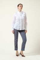 Model wearing the DALB Arcadia Bloom white shirt with a 3D flower appliqué, architectural collar, and grey tailored trousers against a neutral background.