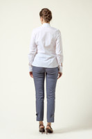 Model wearing the DALB Arcadia Bloom white shirt with a 3D flower appliqué, architectural collar, and grey tailored trousers against a neutral background.