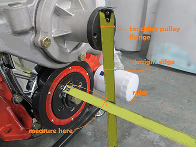 Annotated photo showing where to measure between the balancer face and the water pump pulley flange