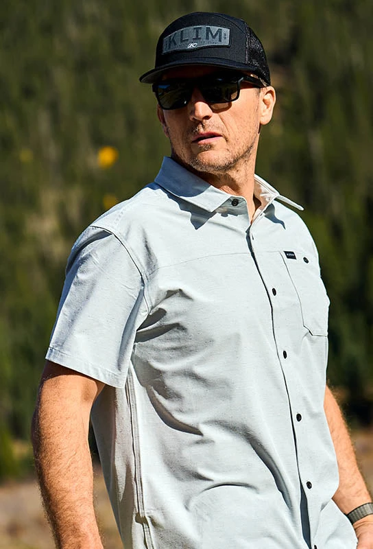 Man wearing a Klim cap and casual shirt outdoors