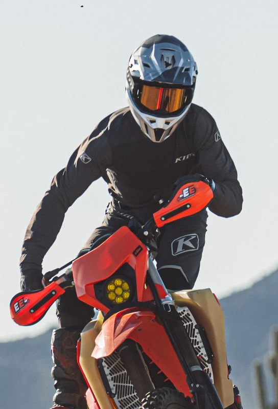 Klim dirt bike rider jumping on a desert trail