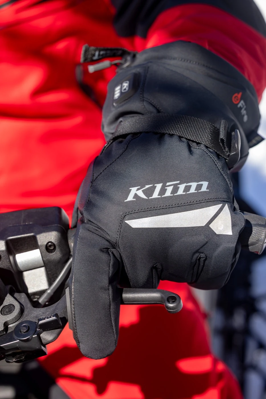 Close-up of a Klim glove on a snowmobile handlebar