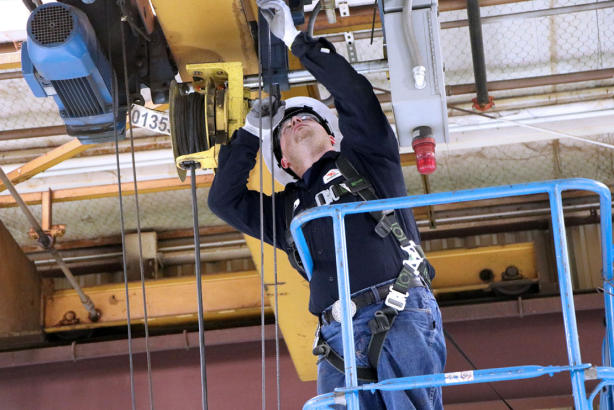 Service technician fixing overhead crane