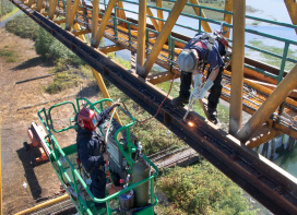 Technicians servicing paper mill crane