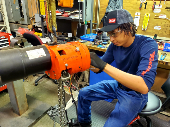 Ace Industries Bench Repair technician repairing hoist 