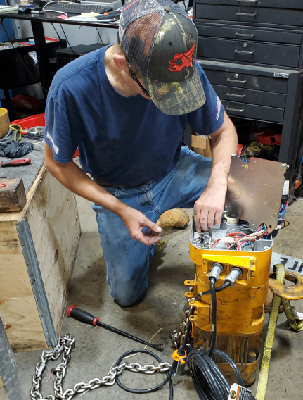 Ace Industries Bench Repair technician repairing hoist 