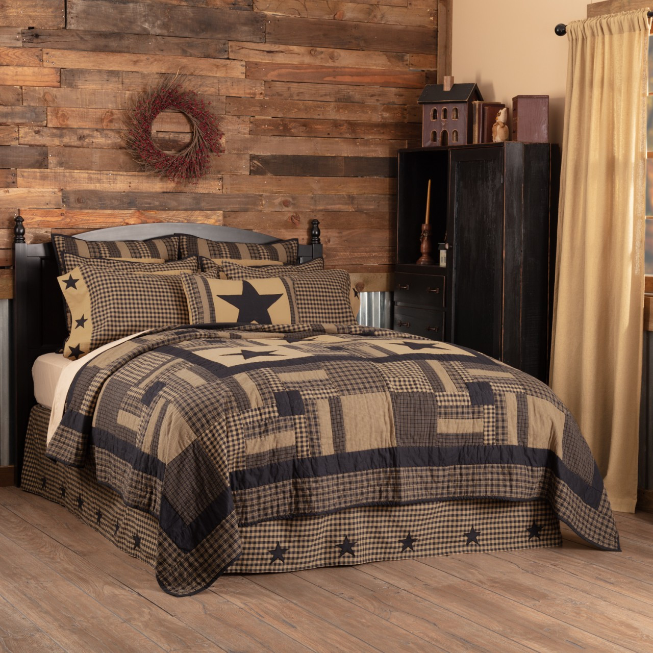 Bed styled with black and tan patchwork bedding