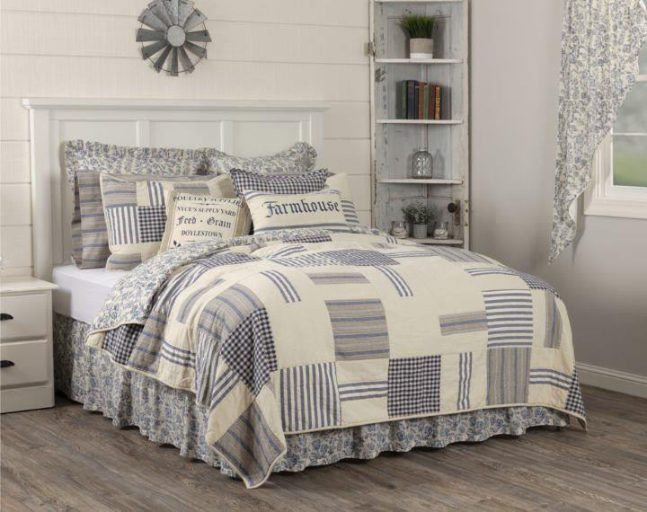 White bed frame styled with blue and white patchwork bedding 