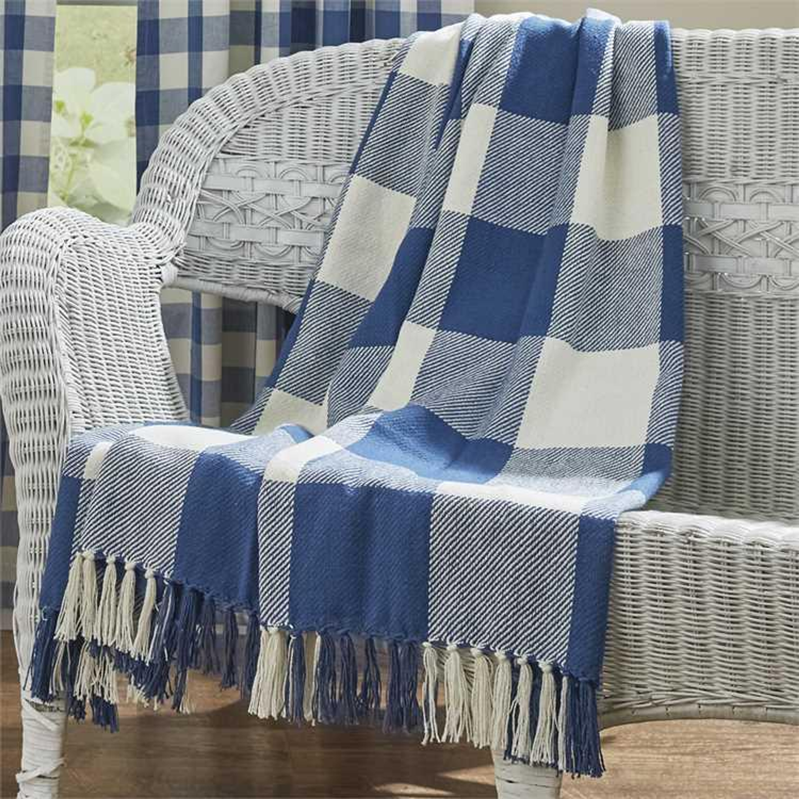 Blue and white check throw draped over a white bench