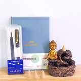 Buddha Statue with Pen and Notebook