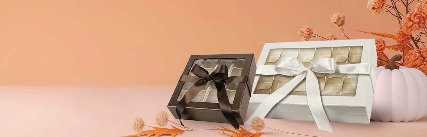 Elegant rigid gift boxes filled with fall treats like truffles and candles