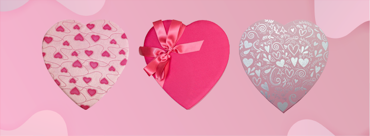 Heart-shaped fabric gift box with a red ribbon and white heart pattern.