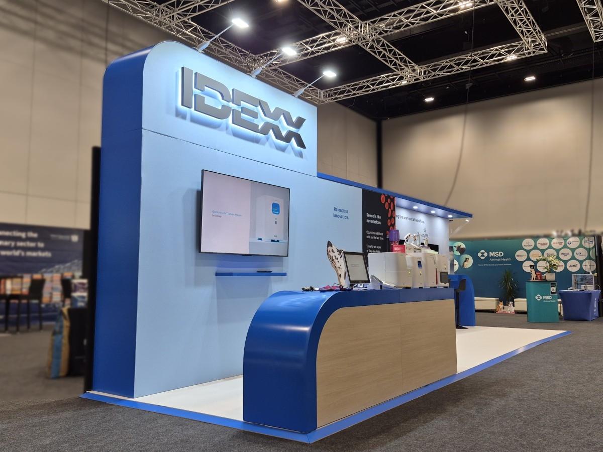 IDEXX exhibition stand at NZVA 2026 with illuminated logo, custom joinery and digital screens