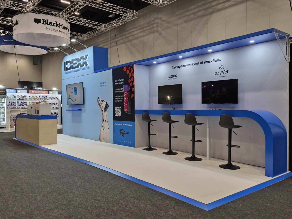 Premium exhibition stand for IDEXX with illuminated branding, custom counters and digital engagement zones