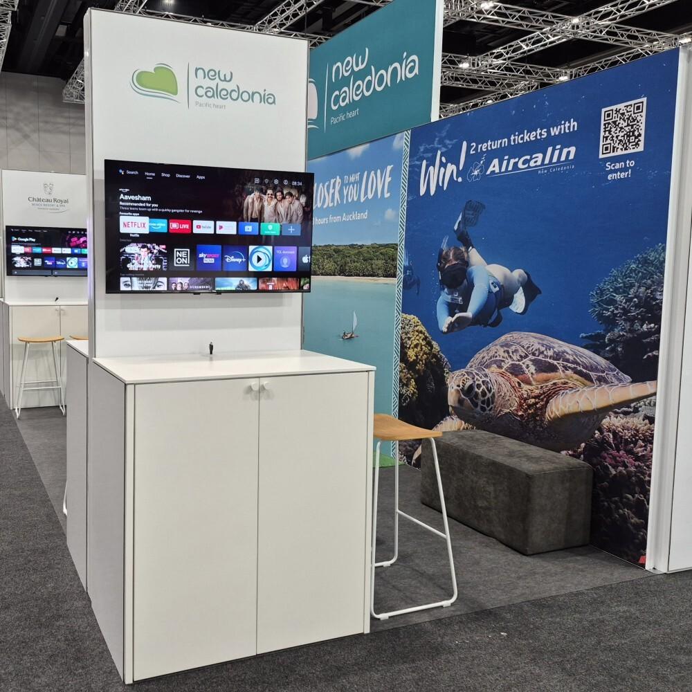 Destination marketing stand for New Caledonia Tourism with digital screen and visitor discussion area