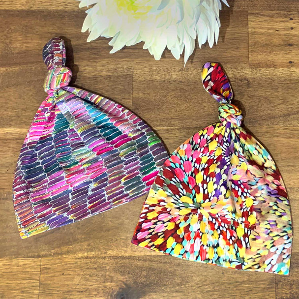 Baby size beanies made from soft bamboo featuring the designs by Aboriginal artists from Central Australia