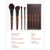 Flat lay of brushes arranged by size and function, surrounded by powder, palette, and mirror