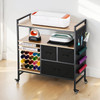 Rolling craft cart workstation in matte black, fully assembled with 20 colorful vinyl rolls stored vertically, a Cricut Maker machine on top, and crafting tools organized in drawers — ideal for home crafters and small business creators.