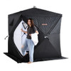 Woman zipping up the front entrance of sauna tent with smile and towel in hand Woman zipping up the front entrance of sauna tent with smile and towel in hand